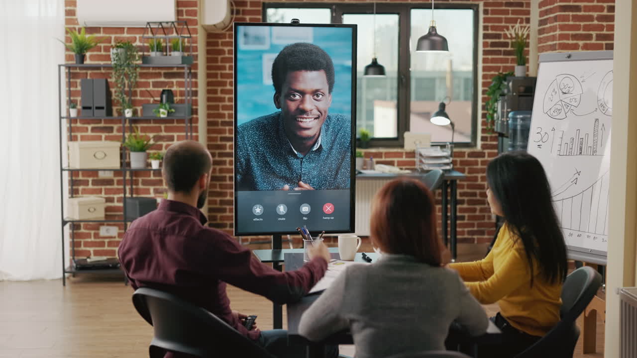 Group of workers using remote video call to talk to man