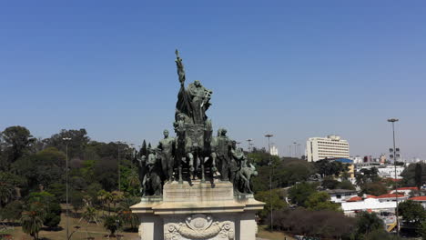 drone flying around the independence monument in the independence park with the independence museum in the background