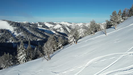 Aerial-View-of-Snowboarder-Walking-Uphill-on-Snowy-Mountain-For-Another-Ride,-Drone-Shot