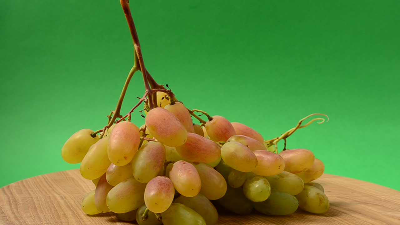 Uva su un tagliere da cucina. Ripresa in movimento