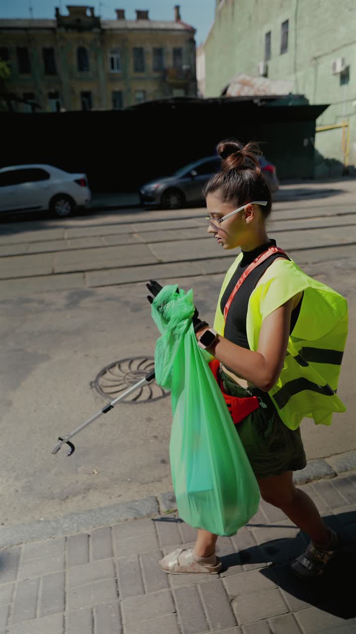 mujer limpiando la basura en la ciudad
