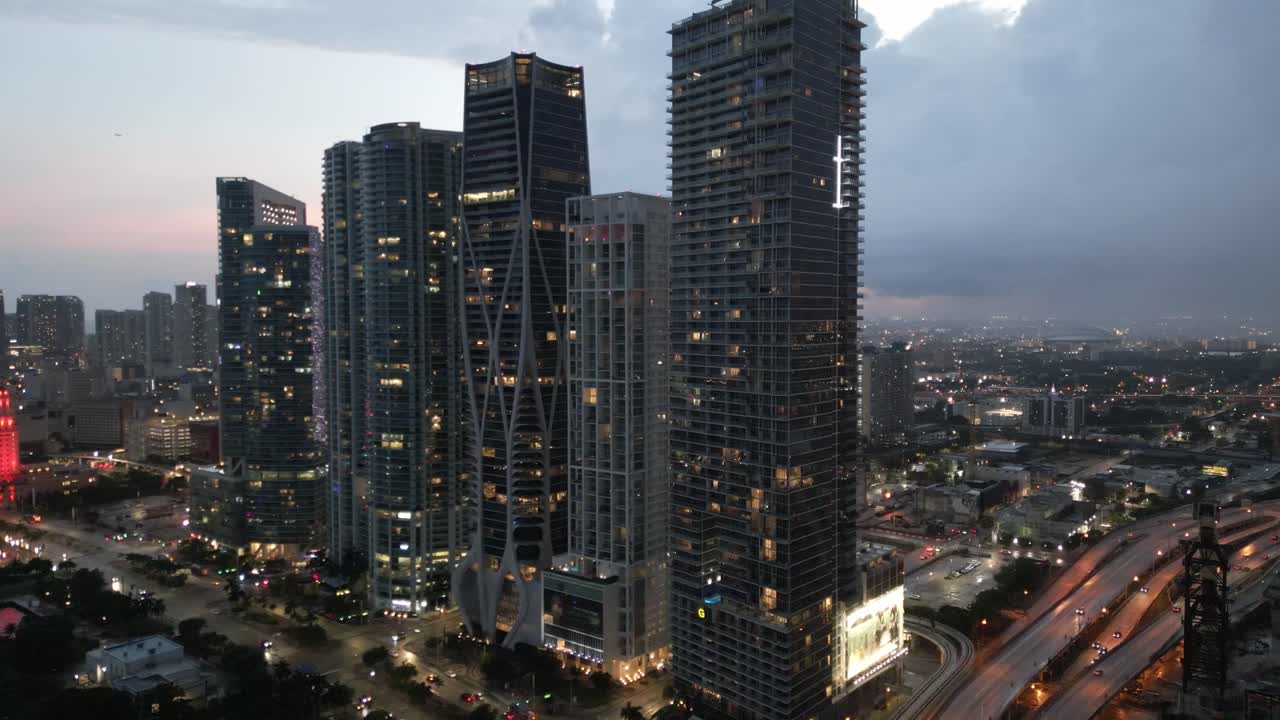 panorámica aérea al atardecer del centro de miami iluminado por la noche con un moderno rascacielos drone revela el horizonte de la ciudad inteligente