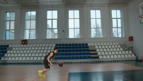 high school team basketball player practicing dunks indoors. 4k uhd