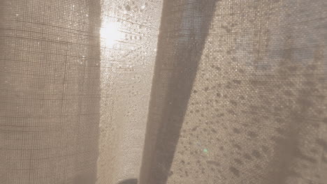 window with morning condensation and light curtain