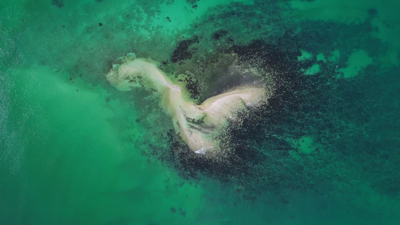 Imagen aérea panorámica que captura varias islas de Tondol rodeadas de agua tropical azul verdosa cristalina