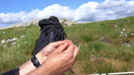 closeup of hands tying a knot for fishing lure during mountain trip in sunny norway