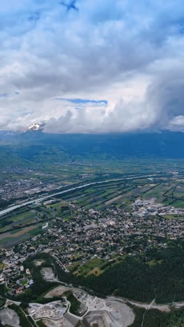 the rhine crossing the scenery of lichtenstein from top. beautiful mountains surrounding the picturesque urban area. top view. vertical video.