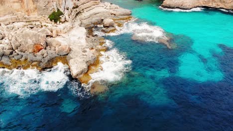 toma aérea de las olas del mar chocan contra los acantilados de la costa de mallorca, españa