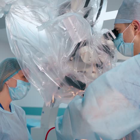 doctors and surgical microscope. neurosurgeon and a nurse in medical uniform perform operation in hospital. new technologies in medicine.