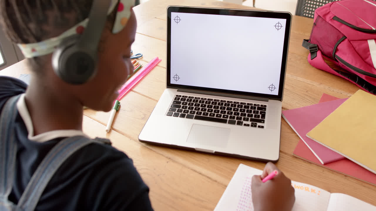 Happy african american girl in online class using laptop with copy space, slow motion
