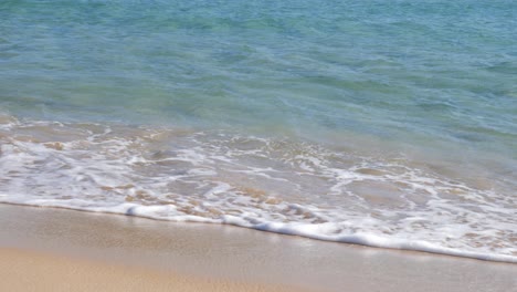 slow motion shot of calm turquoise water hitting sandy beach on seashore in southern sardinia, italy