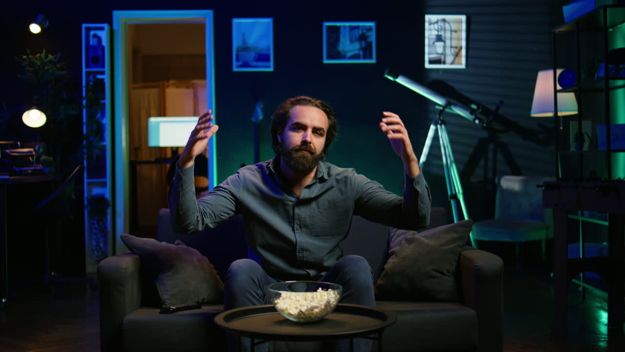 hombre deprimido en casa en el sofá viendo un partido deportivo en vivo