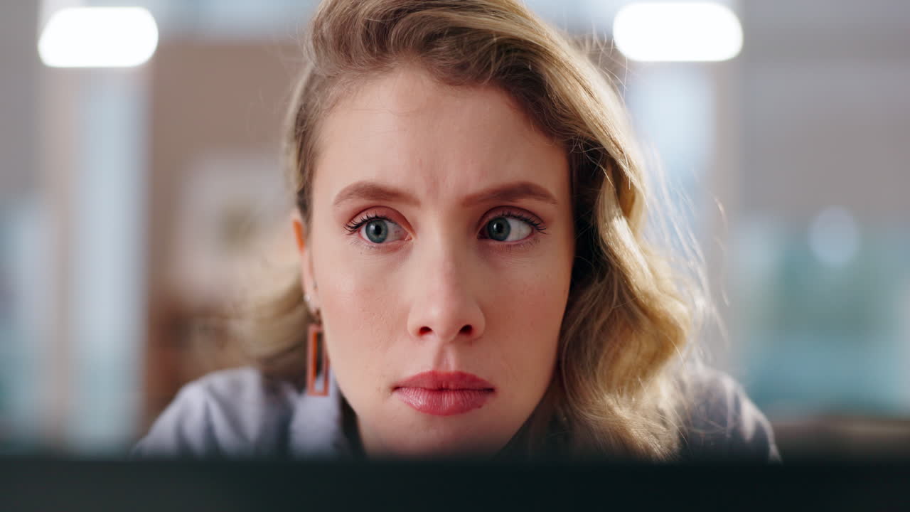 Close-up of a concerned woman looking at a computer screen