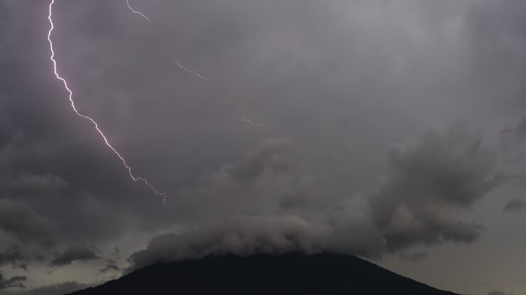 Tuoni da un cielo nuvoloso sul vulcano Agua, Antigua Guatemala.