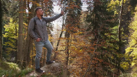 hombre tomando una selfie en un bosque de otoño