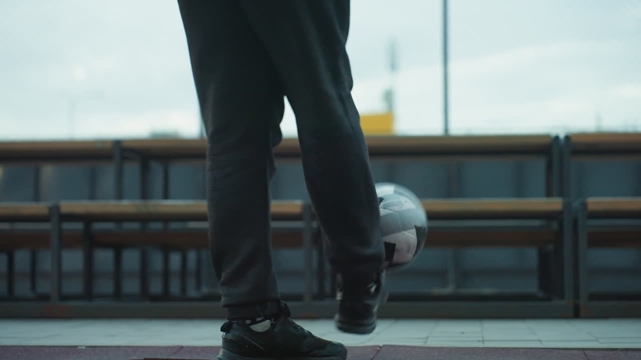 스포츠 경기장에서 능숙하게 글링하는 선수의 다리 시각, 벤치와 조명된 경로로 도시 배경에 집중과 운동 능력을 보여줍니다.