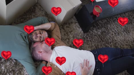 animation of heart icons over diverse gay couple lying