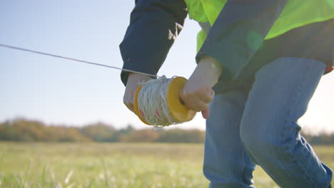 close-up view, surveyor measuring land using calibrated rope and plummet