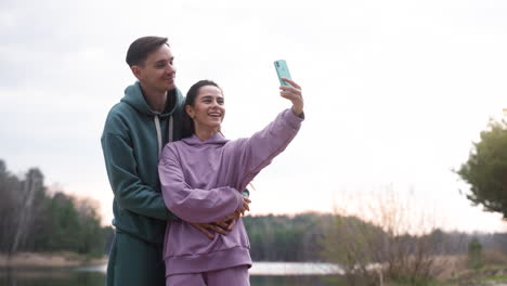 pareja tomando selfies en el bosque