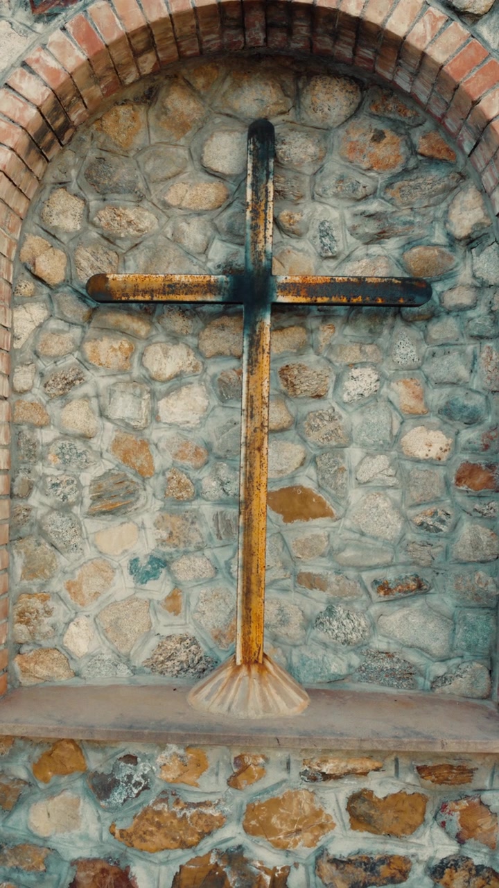 Crucifijo de Jesús cristiano al aire libre en una escena con paredes y ladrillos