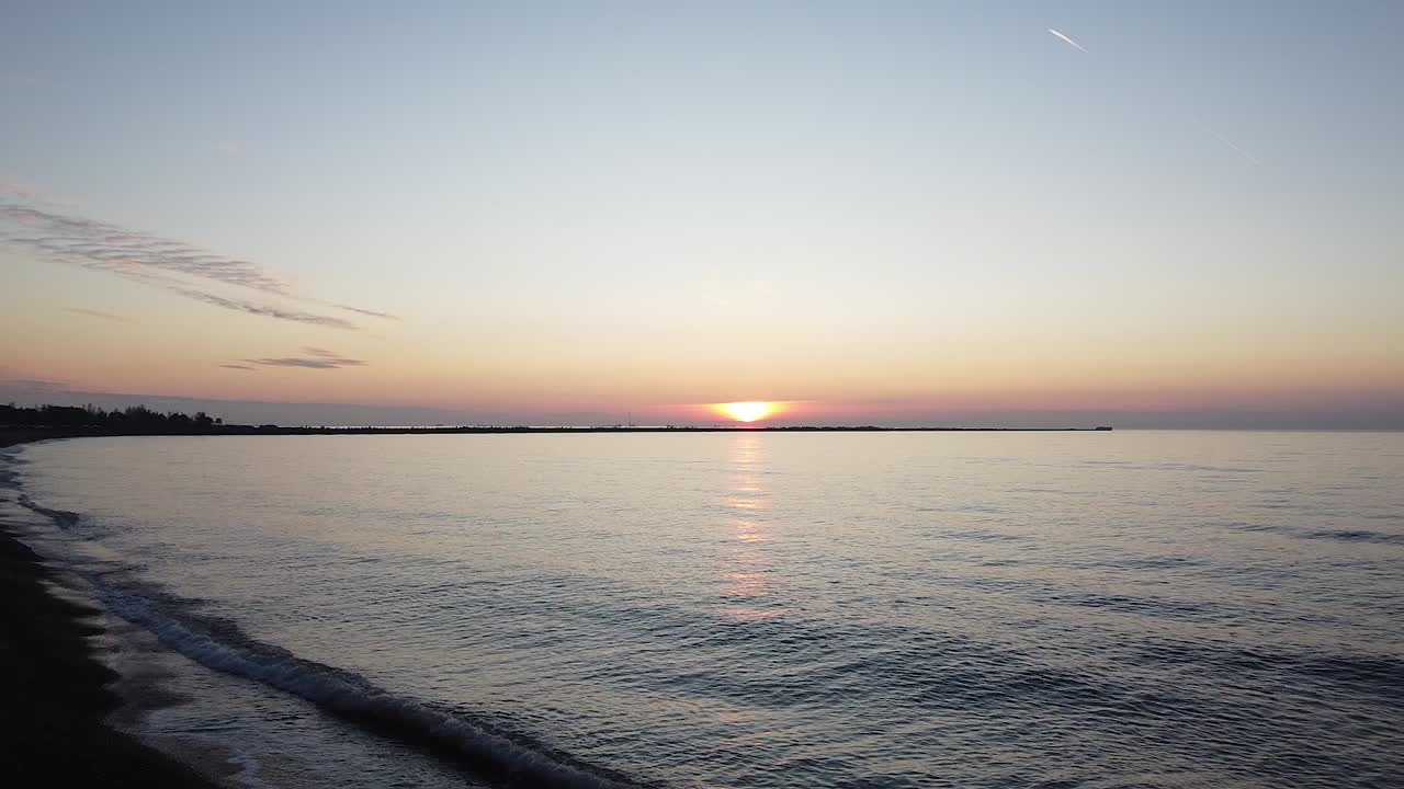 Beautiful vibrant high contrast sunset flyove over the Baltic sea at Liepaja Karosta war port Northern pier, wide angle establishing drone shot moving forward