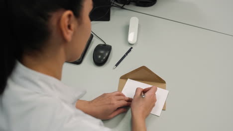 woman writing 'girl' on a paper