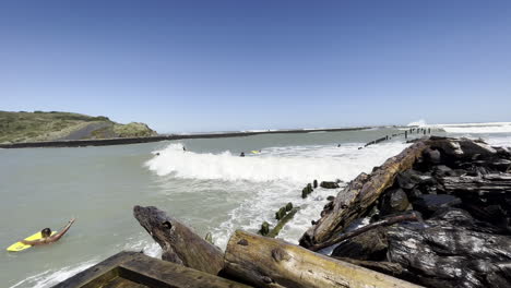 surfistas golpeados por olas espumosas en la playa de patea, taranaki, nueva zelanda en verano