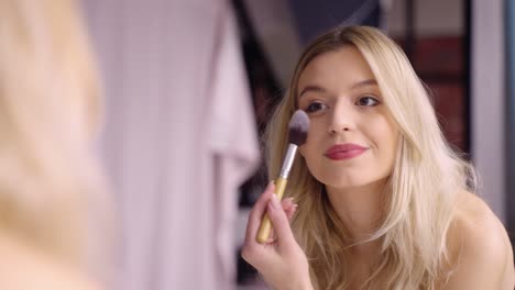 vrouw die blush make-up aanbrengt
