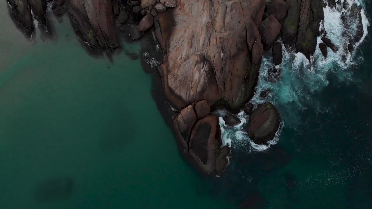 Sorvolo dall'alto che rivela l'intera roccia di Arpoador a Rio de Janeiro, appena fuori dal quartiere della spiaggia di Ipanema, luogo popolare per gli abitanti del posto per applaudire il tramonto.