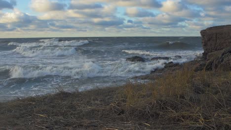 grandes olas tormentosas rompiendo contra las ruinas abandonadas del edificio de la fortificación junto al mar en los fuertes del norte de karosta en liepaja, tiro ancho en cámara lenta