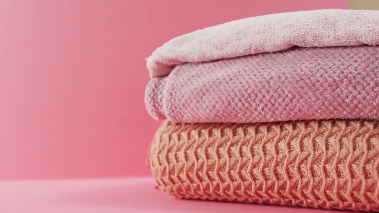Video di coperte piegate appoggiate su sfondo rosa