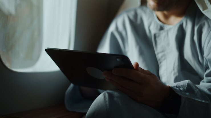Man using a tablet device near a window