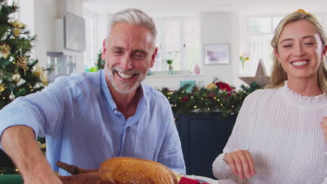 Multi-Generation-Family-Celebrating-Christmas-At-Home-Saying-Prayer-Before-Eating-Meal-Together