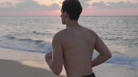 Schöner-Sportlicher-Mann,-Der-Bei-Sonnenuntergang-Am-Strand-Läuft