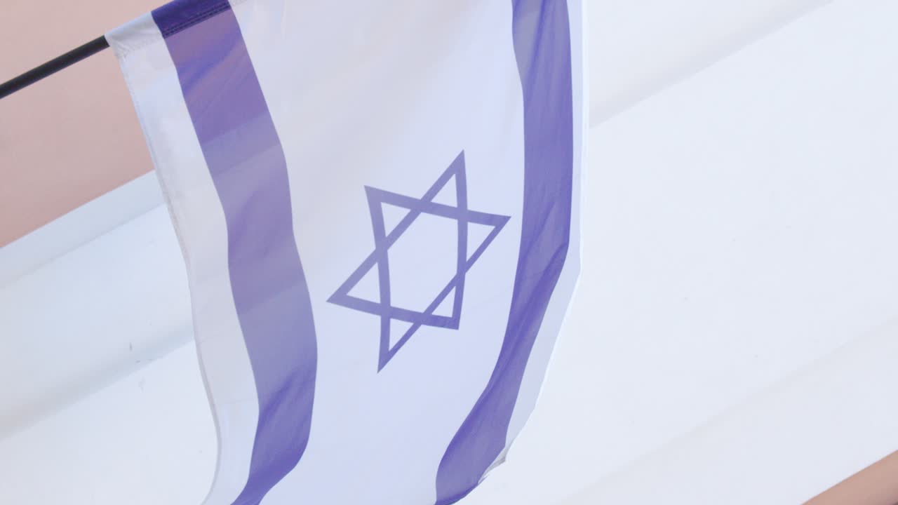 Israeli flag flutters in gentle breeze, captured in soft natural light with steady camera angle