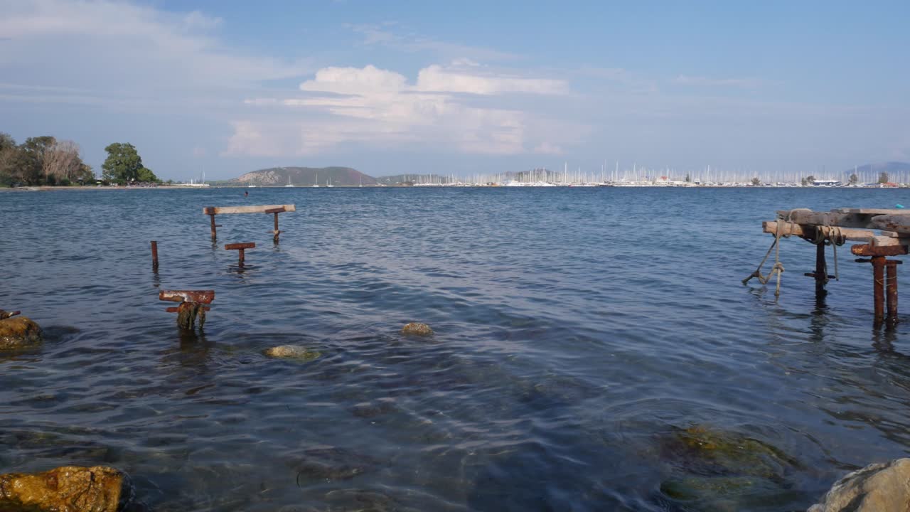 Serene Seascape with Old Wooden Dock and Sailboats in the Distance