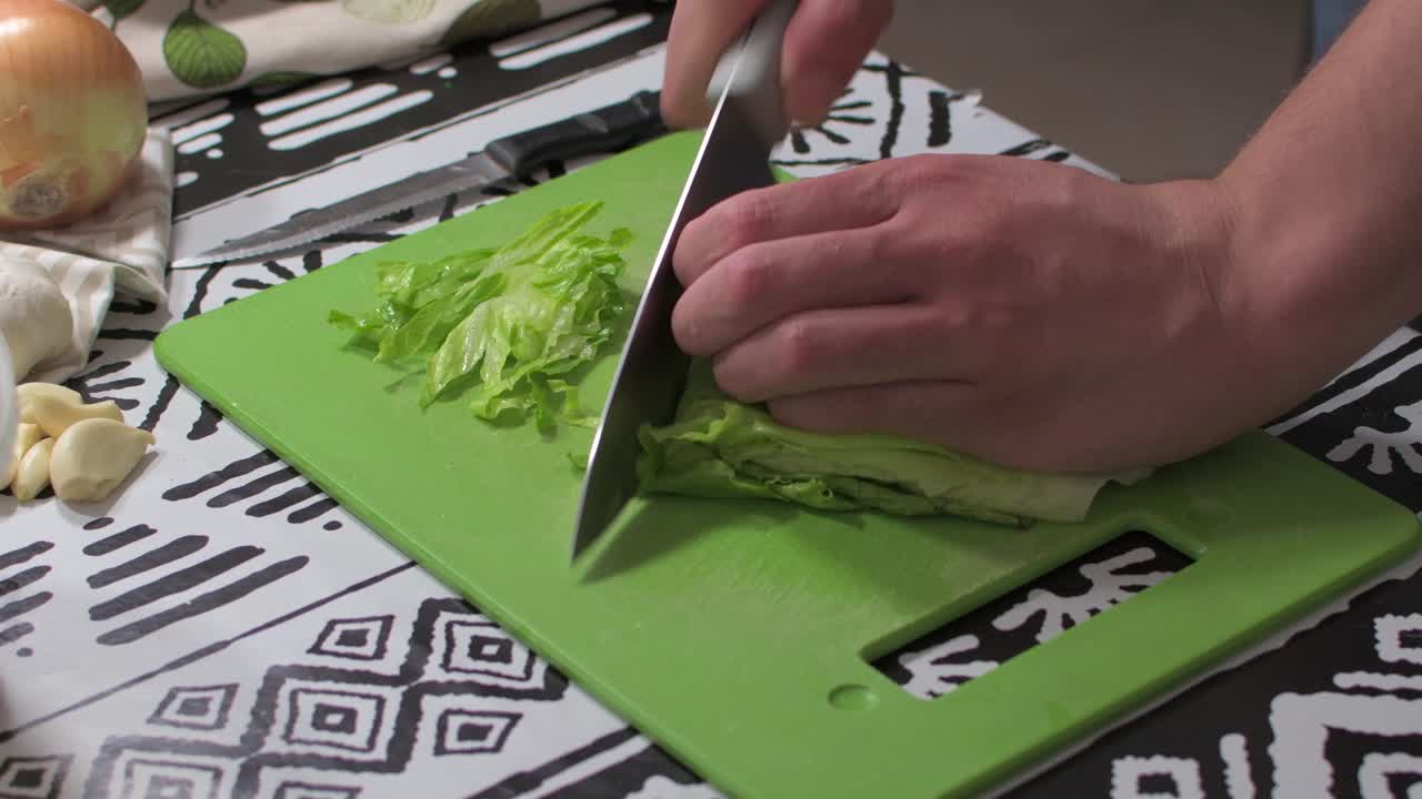 Male hands cutting lettuce