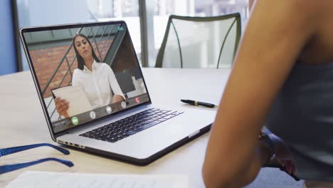 Video-of-african-american-woman-having-video-call-on-laptop-with-biracial-female-coworker