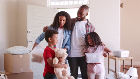 familia emocionada llevando cajas a su nuevo hogar el día de la mudanza