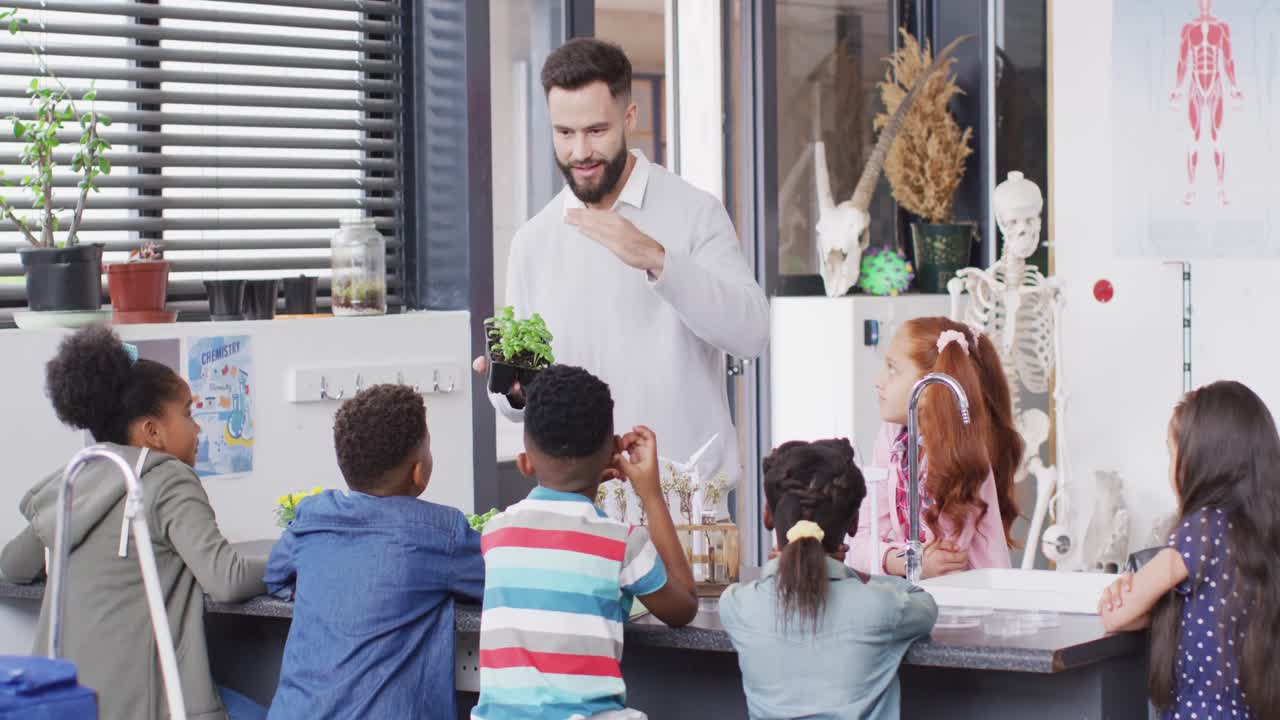 diversos maestros varones y escolares felices estudiando plantas en el aula de la escuela