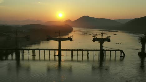 bridge construction on the river at sunset