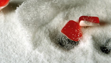 heart shaped candies falling in pile of sugar