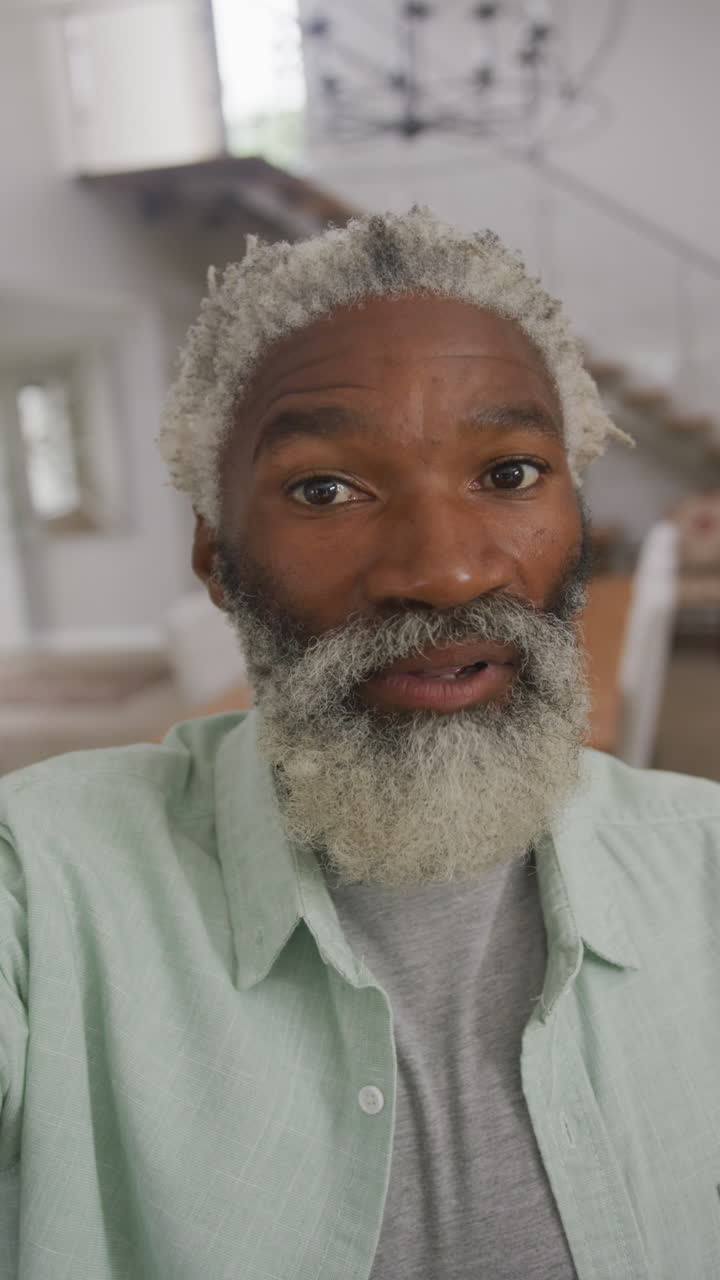 video vertical del retrato de un anciano afroamericano feliz hablando en casa