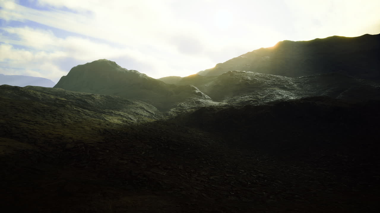 Mountains illuminated by the golden light of dawn over a rugged terrain