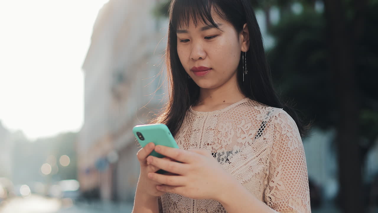 Asian woman using smartphone outdoors