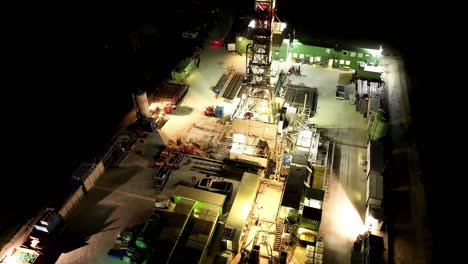 aerial of oil drilling rig illuminated at night