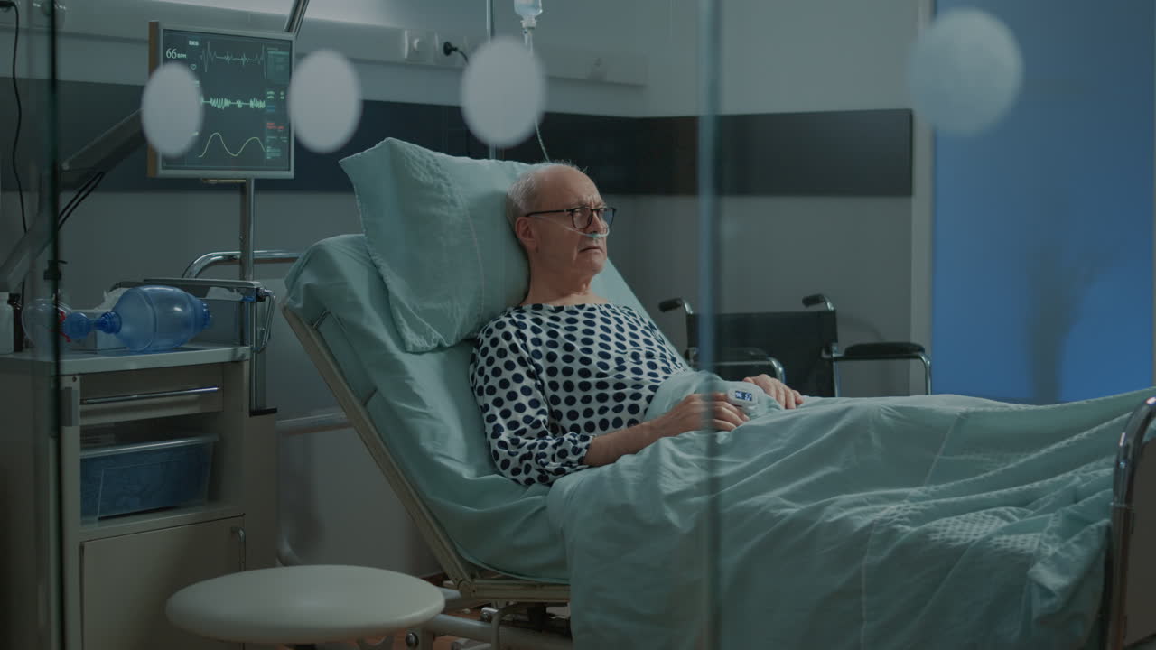 Ill patient with nasal oxygen tube and IV drip bag