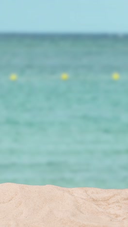 video concepto de vacaciones de verano vertical con playa de arena en primer plano contra el fondo del mar