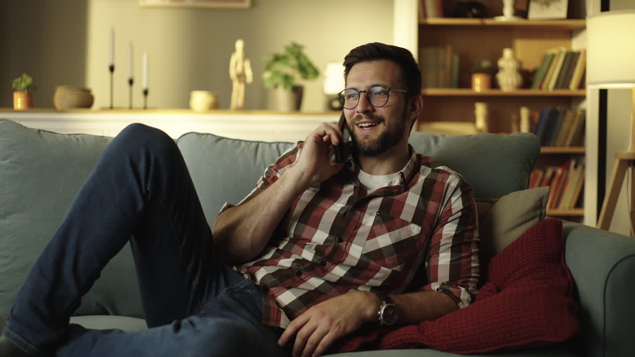 Man talking on the phone while relaxing on the couch at home