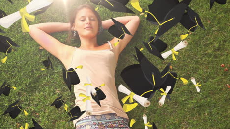 sombreros de graduación volando sobre una chica acostada en el césped